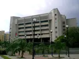 La sede de concreto del Tribunal Supremo de Justicia de Venezuela en Caracas, con palmeras y faroles al frente.