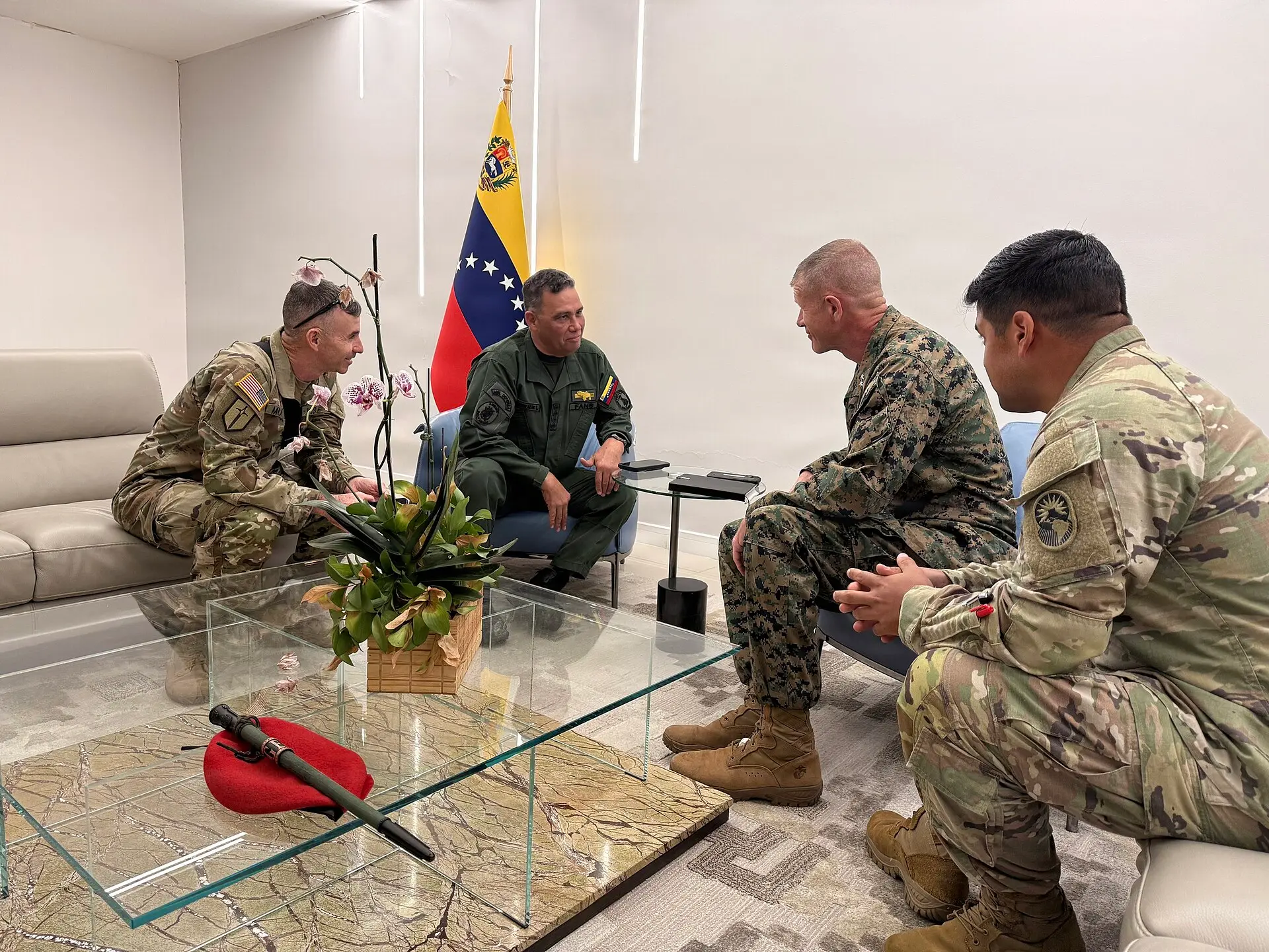 El general Gustavo González López, con uniforme verde junto a una bandera venezolana, se reúne con oficiales militares de EE. UU.
