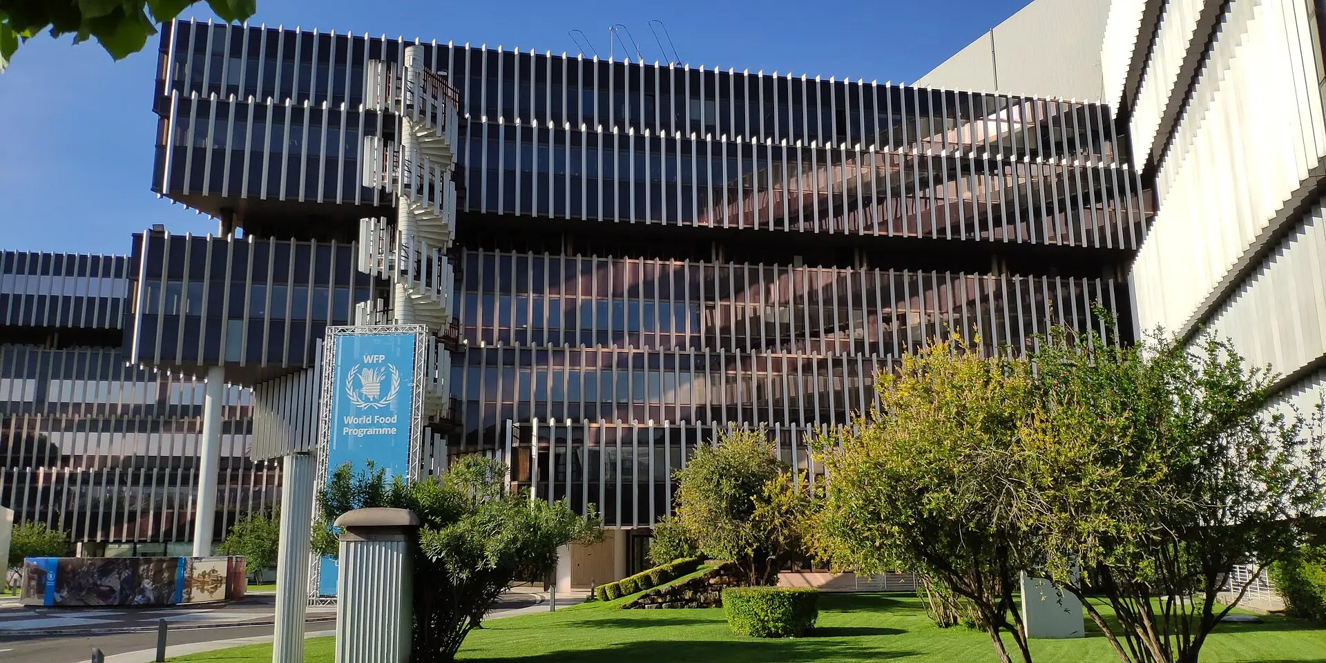 The modern headquarters building of the UN World Food Programme in Rome, with its blue WFP sign.