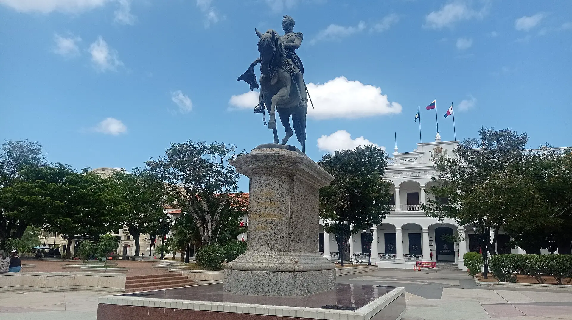 Equestrian statue of Simón Bolívar in Plaza Bolívar, Maracaibo, with the white Zulia government palace behind it.