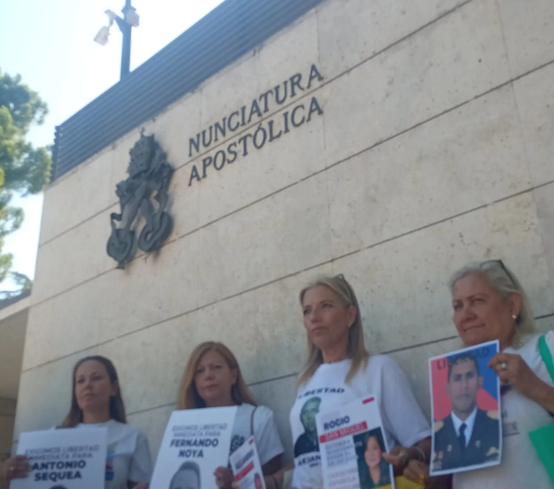 Women hold photos of Venezuelan political prisoners outside the Apostolic Nunciature in Madrid.