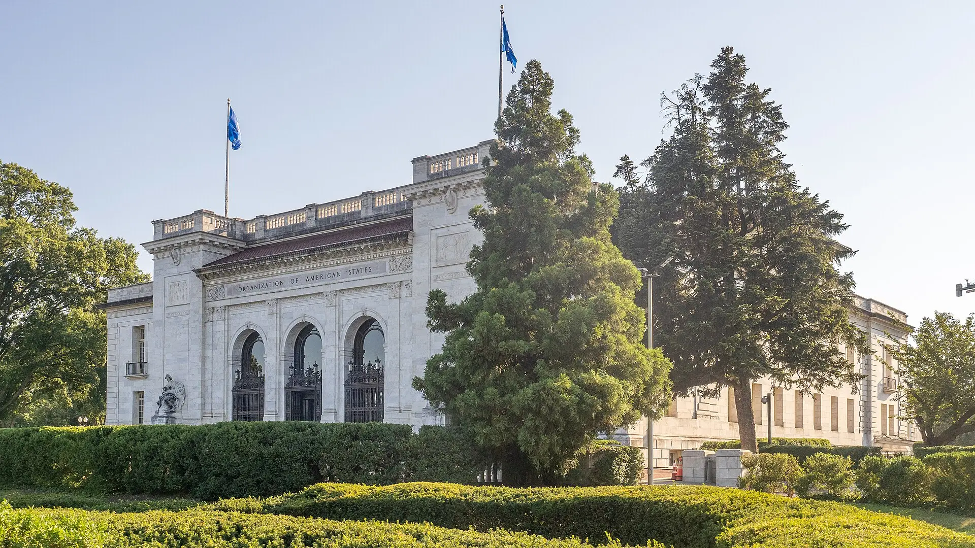 The marble Pan American Union Building, headquarters of the OAS in Washington, with OAS flags flying over it.