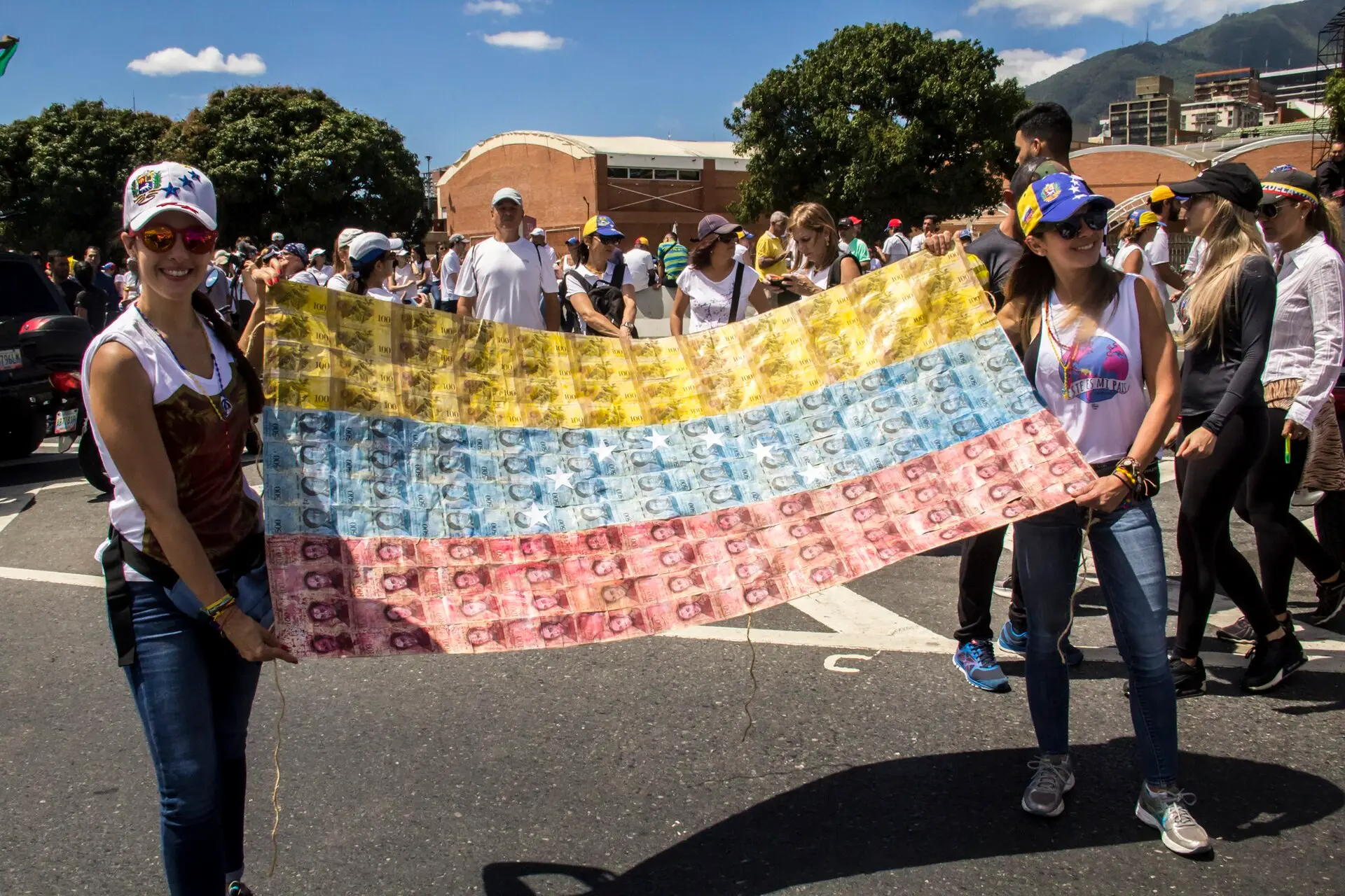 Protesters in Caracas hold a large Venezuelan flag made of worthless bolívar banknotes.